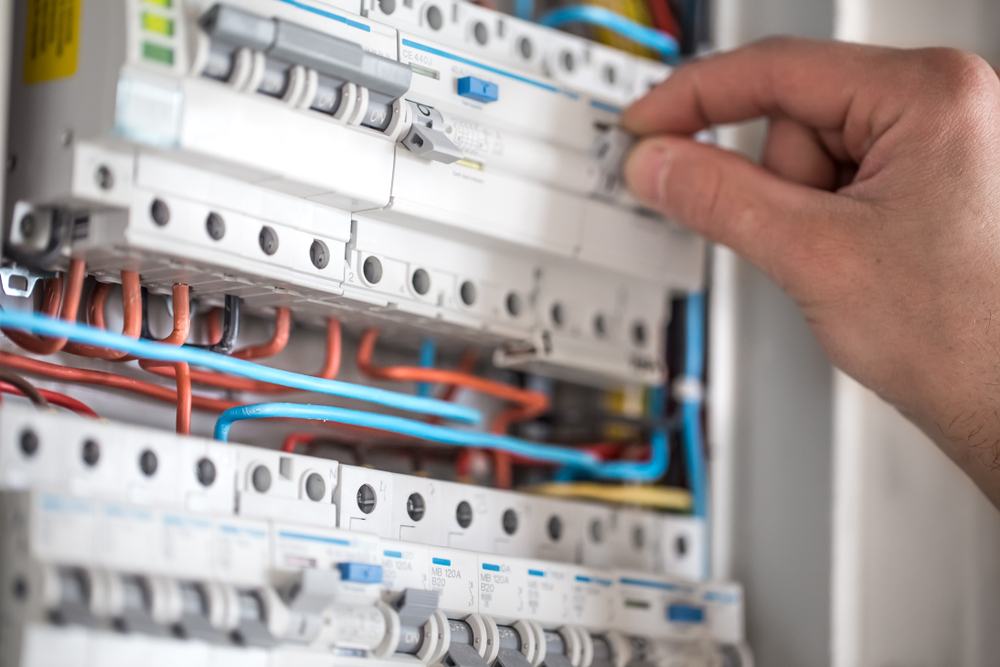 A person checking a fuse box